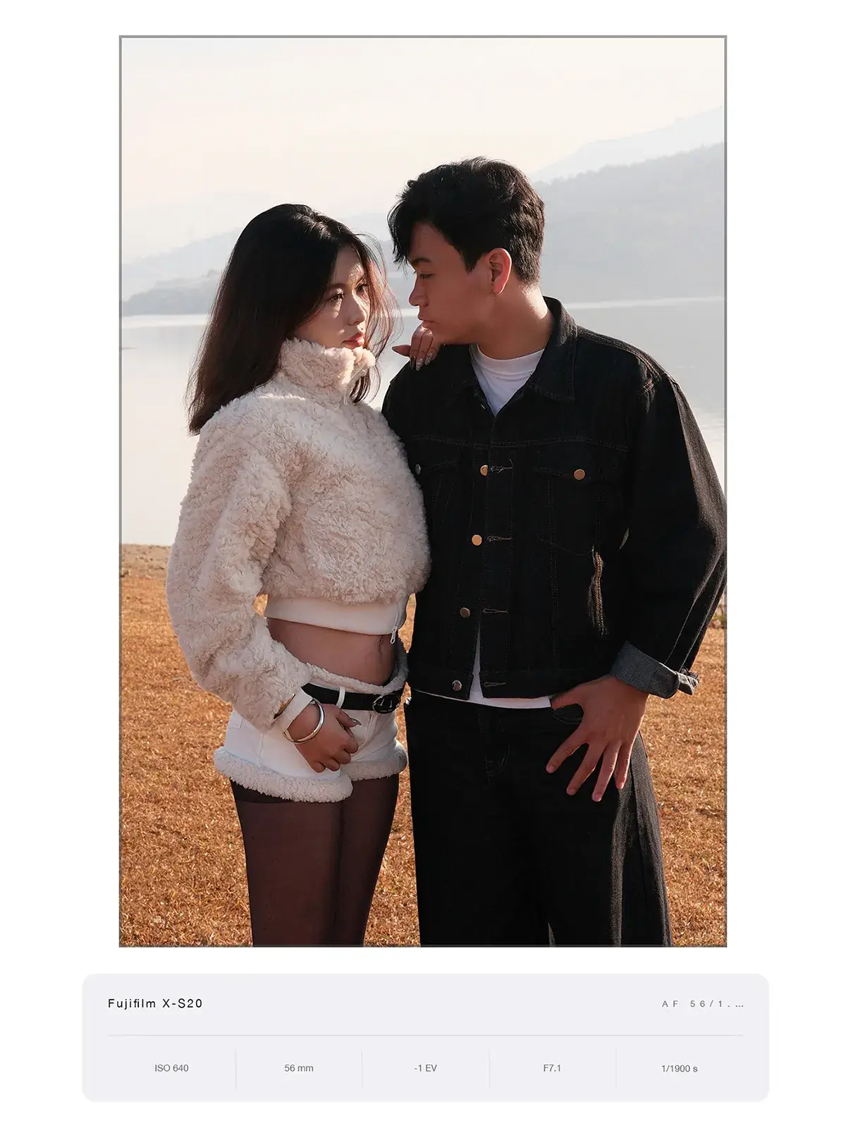 Ảnh đôi nam nữ đứng đối diện nhau trên đồi cỏ khô bên mặt nước, chụp bằng Fujifilm X-S20