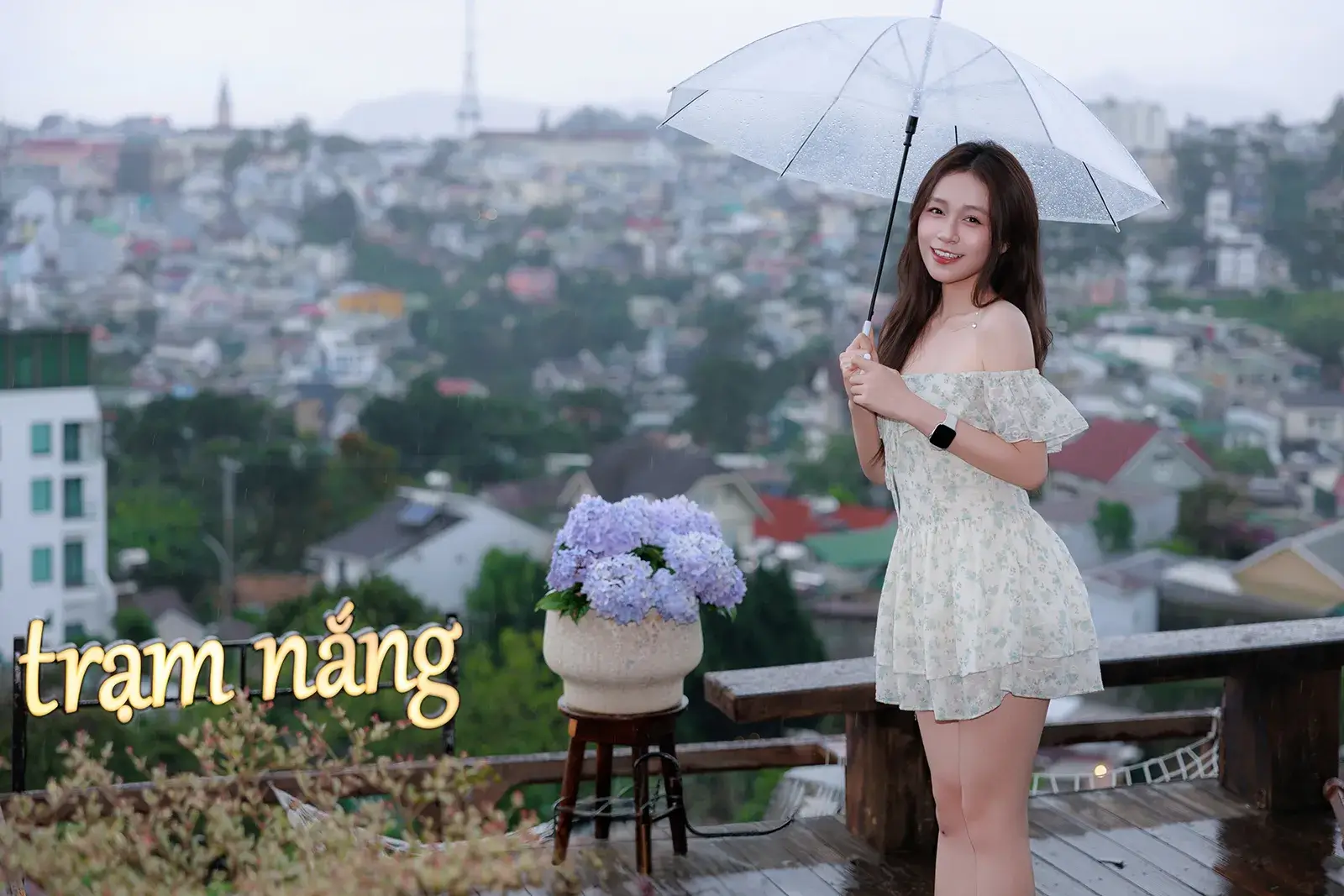 Chân dung cầm dù trong suốt trên ban công nhìn ra thành phố Đà Lạt