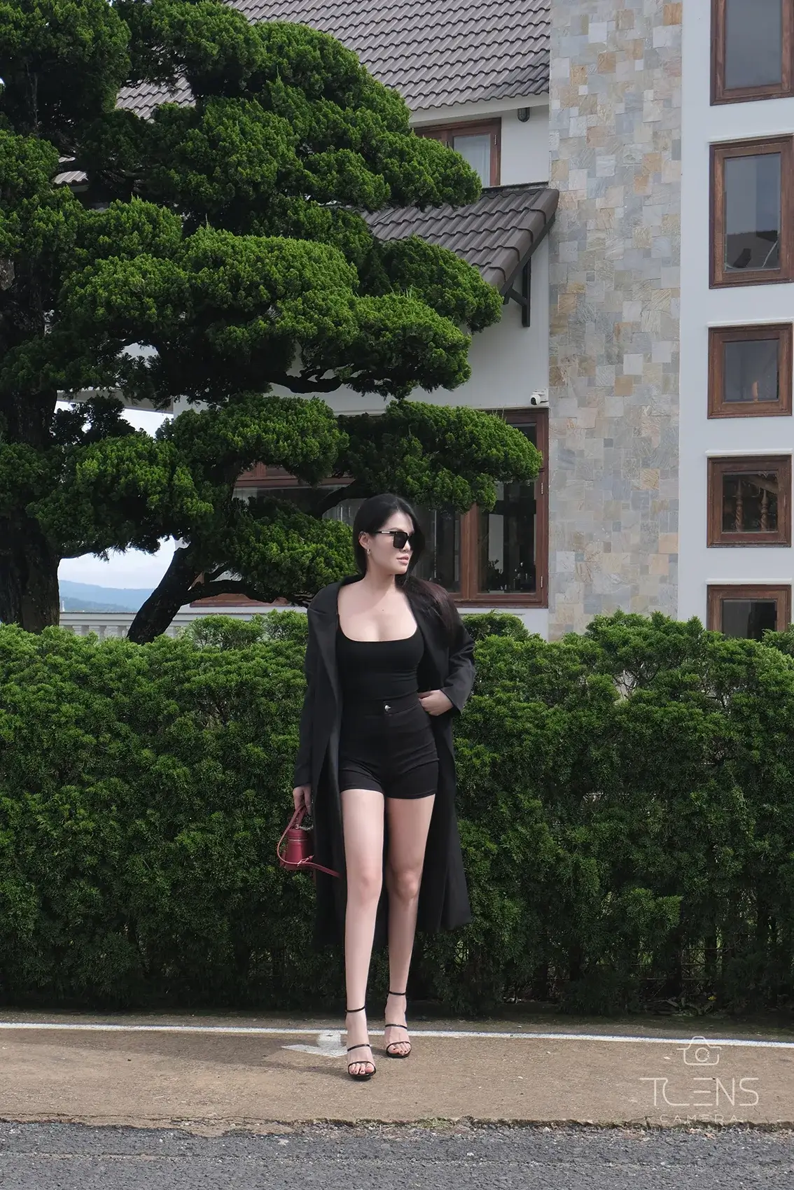 Ảnh outfit toàn thân ngoài trời của một phụ nữ mặc đồ đen, chụp bằng Fujifilm X-S10 với XC 15–45mm